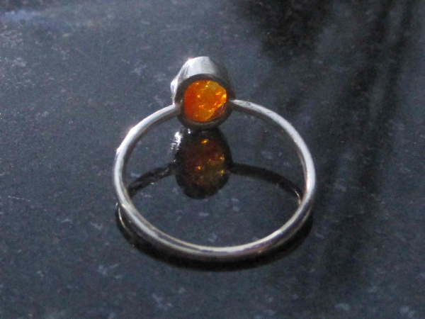 A handmade US size 6.5 fire opal silver stacking ring made with a rough oval sha