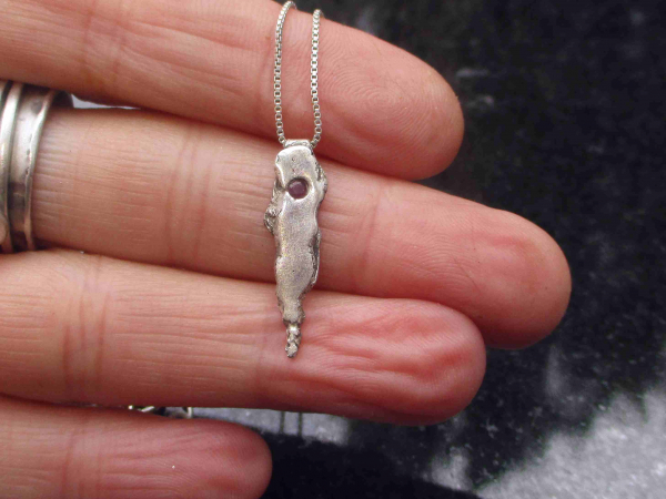 A handmade unique recycled silver pendant with a small pink sapphire. Solid Silv